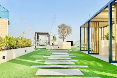 a garden with grass and a walkway at Canal View Studio Jacuzzi in Dubai
