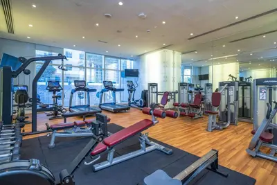 a gym with several treadmills and machines at Chic Waterfront 1 Bed with Panoramic Marina Views in Dubai