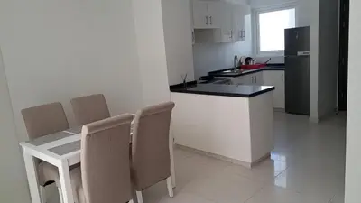 a kitchen with a table and chairs and a counter top at Damac hills 2 vardon cluster townhouse in Dubai