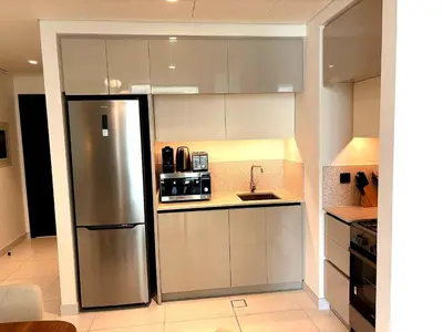 a kitchen with a refrigerator and a sink at Palm View Marina Vista 1BR Beachfront in Dubai