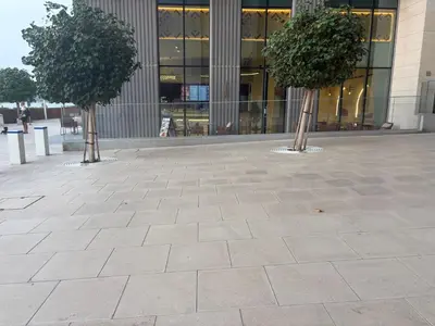 two trees in a courtyard in front of a building at Palm View Marina Vista 1BR Beachfront in Dubai