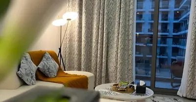a living room with a couch and a window at Laya Heights Residence by Hogar in Dubai