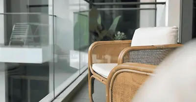 a wicker chair sitting on a balcony next to a window at Laya Heights Residence by Hogar in Dubai