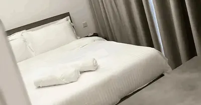 a white bed with white sheets and pillows at Laya Heights Residence by Hogar in Dubai