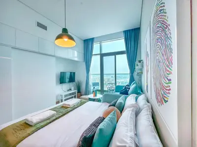 a bedroom with a large bed with a couch at Minimal Studio in Marina Sea View in Centric & Top Building in Dubai