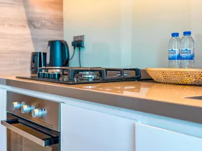 a kitchen with a stove and bottles of water on a counter at Minimal Studio in Marina Sea View in Centric & Top Building in Dubai
