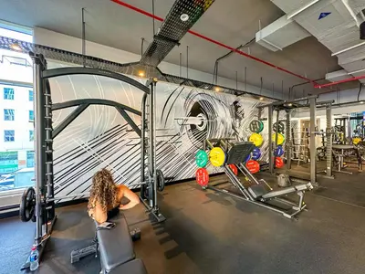 a woman in a gym with a mural on the wall at Minimal Studio in Marina Sea View in Centric & Top Building in Dubai