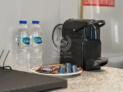 a toaster and two bottles of water on a counter at Royalton - Cozy Studio with Burj Khalifa & Canal Views in Dubai