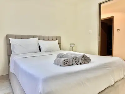 a bedroom with a large white bed with towels on it at Renovated 2bdr in Sadaf 7 JBR in Dubai