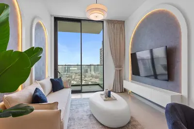 a living room with a couch and a tv at Tranquil 1Bedroom in Binghatti Gardenia in Dubai