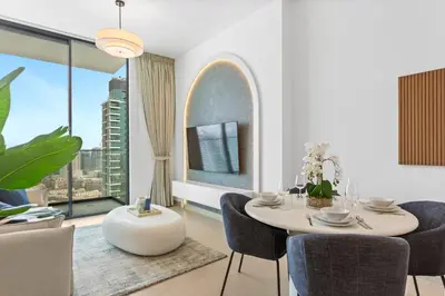 a dining room with a table and chairs and a large window at Tranquil 1Bedroom in Binghatti Gardenia in Dubai