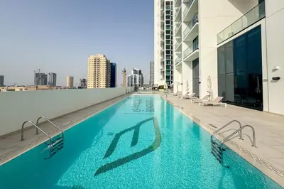 a swimming pool on the roof of a building at Tranquil 1Bedroom in Binghatti Gardenia in Dubai