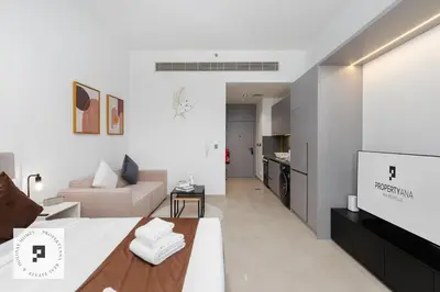a living room with a large bed and a couch at Affordable New Studio I MAG 980 I Summer Deal in Dubai