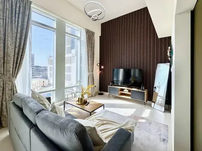 a living room with a couch and a large window at Luxury Apt Near Burj & Metro in Dubai