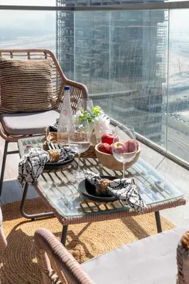 a table with a bowl of fruit and wine glasses at Frank Porter - MADA Residences, Downtown in Dubai