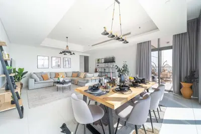 a dining room and living room with a table and chairs at Frank Porter - MADA Residences, Downtown in Dubai