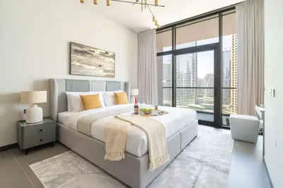 a bedroom with a large bed and a large window at Frank Poretr - MBL Royal, Jumeirah Lakes Towers in Dubai