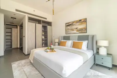 a bedroom with a large white bed with a night stand at Frank Poretr - MBL Royal, Jumeirah Lakes Towers in Dubai