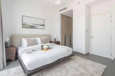 a bedroom with a large bed with a table on it at Frank Porter - Kensington Waters, Sobha Hartland in Dubai