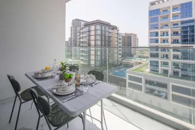 a table and chairs in a room with a large window at Frank Poretr - The Pinnacle, Dubai Hills in Dubai