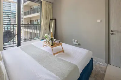 a bedroom with a large bed and a balcony at Frank Porter - Zada Tower in Dubai