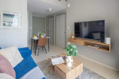 a living room with a blue couch and a tv at Frank Porter - Zada Tower in Dubai