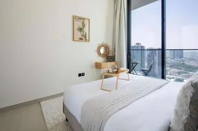 a bedroom with a white bed and a large window at Frank Porter - Binghatti Tulip in Dubai