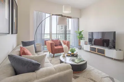 a living room with a couch and a tv at Frank Porter - Grande Signature Residences in Dubai