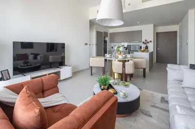 a living room and kitchen with a couch and a table at Frank Porter - Grande Signature Residences in Dubai