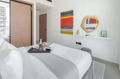 a bedroom with a white bed and a mirror at Frank Porter - Binghatti Amber in Dubai