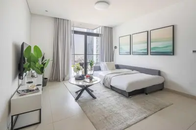 a bedroom with a bed and a tv and a table at Frank Porter - Burj Crown in Dubai
