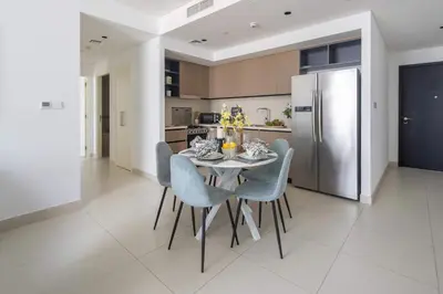 a kitchen with a table with chairs and a refrigerator at Frank Porter - Burj Crown in Dubai