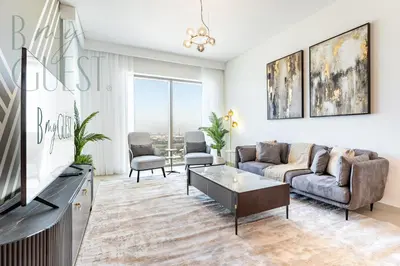 a living room with a couch and a tv at Spice of Sophistication in a 2BR Downtown Views II in Dubai
