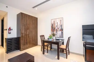 a dining room with a table and chairs and a television at Elite Haven, Elegant Escape in Dubai - Free Pool in Dubai
