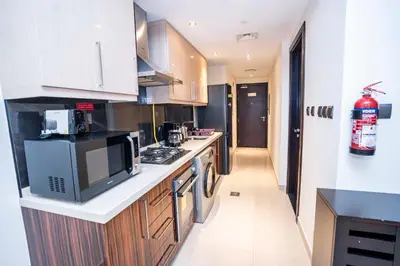 a kitchen with a microwave and a stove top oven at Elite Haven, Elegant Escape in Dubai - Free Pool in Dubai