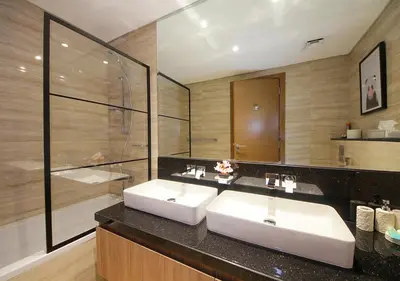 a bathroom with two sinks and a large mirror at Urban Oasis 2BR Retreat in Dubai with Pool View in Dubai