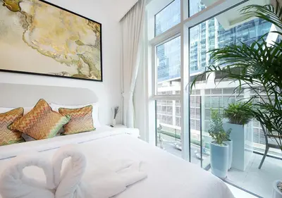 a bedroom with a white bed with two swans on it at Urban Oasis 2BR Retreat in Dubai with Pool View in Dubai