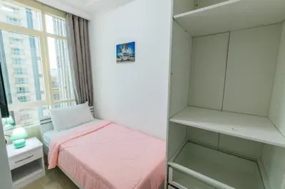 a small bedroom with a pink bed and a window at Must update to luxury studio in heart of marina Dubai in Dubai
