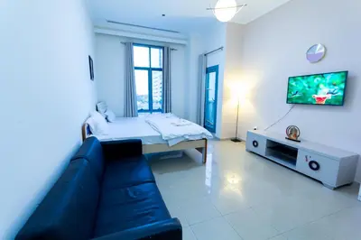 a living room with a couch and a tv at Must update to luxury studio in heart of marina Dubai in Dubai