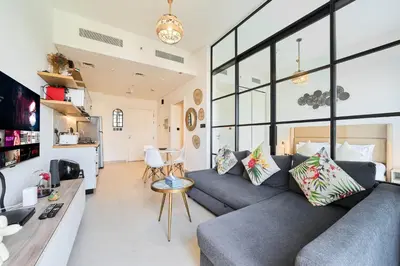 a living room with a couch and a table at Chic 1BR With Balcony in Collective 2 Dubai Hills in Dubai
