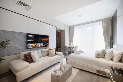 a living room with a white couch and a large window at LUXE Rooftop Infinity Pool 5 Mins to JBR Dubai Marina View in Dubai