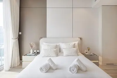 a white bedroom with a large white bed with white pillows at LUXE Rooftop Infinity Pool 5 Mins to JBR Dubai Marina View in Dubai