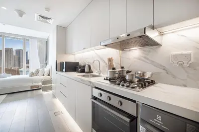 a white kitchen with a stove and a sink at LUXE Rooftop Infinity Pool 5 Mins to JBR Dubai Marina View in Dubai
