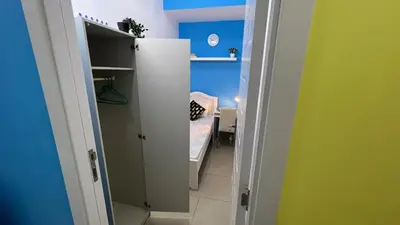 a small room with a bed and a room with a closet at Solo Cabin Room in Tecom Barsha Heights in Dubai