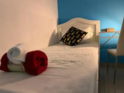 a small bed with a red blanket and a pillow at Solo Cabin Room in Tecom Barsha Heights in Dubai