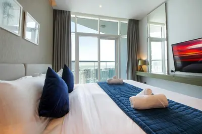 a bedroom with a large bed with a large window at Stylish Damac Prive Studio on hghFlr with Canal View in Dubai