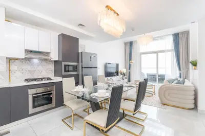 a kitchen and dining room with a table and chairs at StayShort - Beautiful Al Furjan 2 bed apartment for 4 people in Dubai