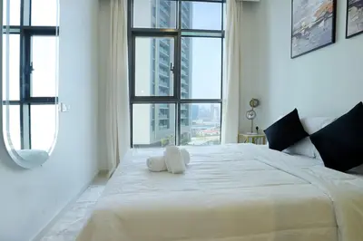 a white bed with a stuffed animal on top of it at 2BR I Aykon City I Business Bay I Bshh in Dubai