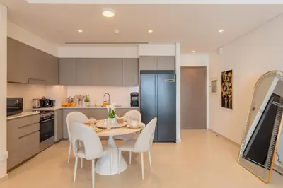 a kitchen and dining room with a table and chairs at Grande Signature Residence by Hogar in Dubai