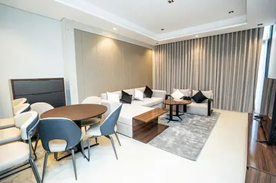 a living room with a table and chairs and a couch at High-Rise Comfort 2BR in Nobles Tower in Dubai in Dubai